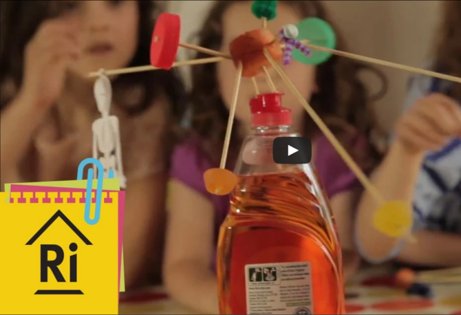 a washing up liquid bottle with a sculpture balancing on top.