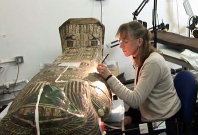 A woman leaning over a sarcophagus