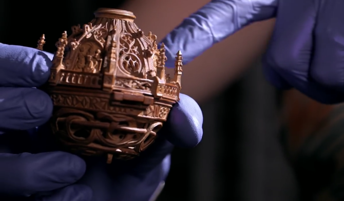 A small carved wooden tabernacle in the hands of a British Museum curator.