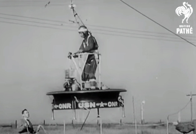 A black and white screenshot showing a man on a flying platform