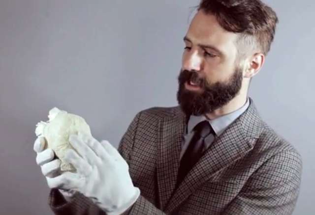 A screenshot showing a man holding some baby clothes