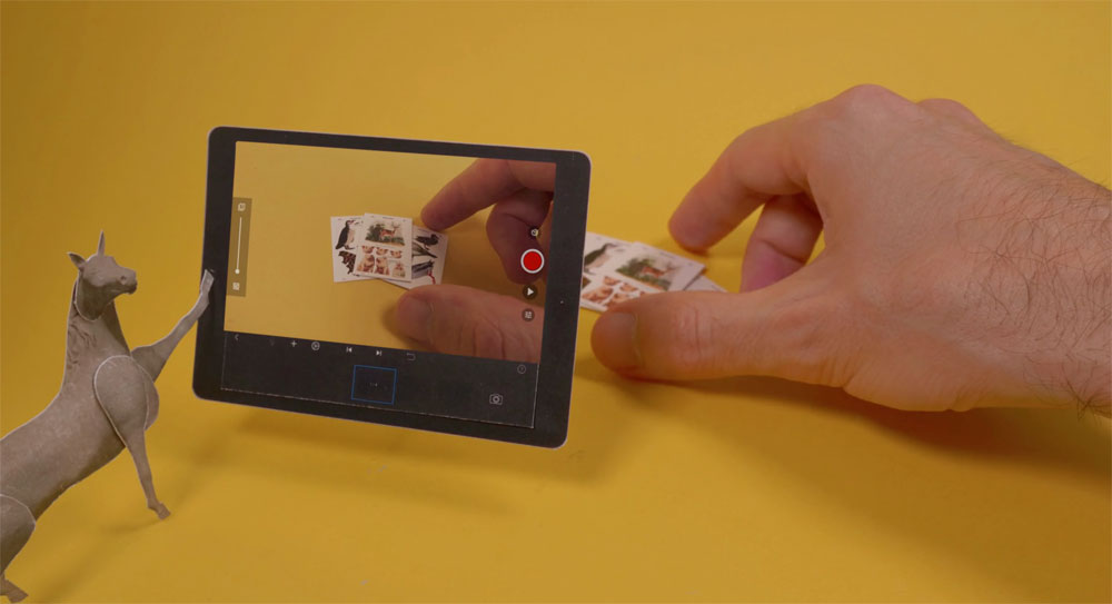 a horse looking at a tablet showing a hand holding a piece of paper